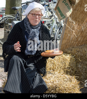 Frau in alten Kostümen essen Pfannkuchen am 1. April 2013 in Brielle, Holland Stockfoto