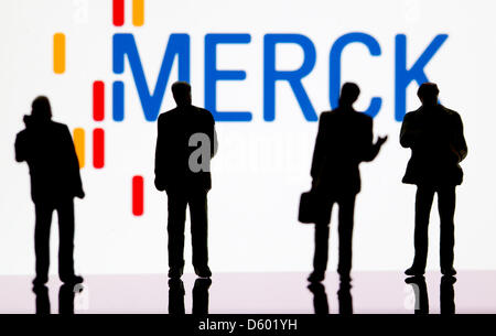 (ABBILDUNG) Eine Abbildung vom 9. November 2012 zeigt kleine Kunststoff-Figuren im Vordergrund des Logos der DAX-Unternehmen: Merck in Berlin, Deutschland, 9. November 2012. Foto: Sven Hoppe Stockfoto