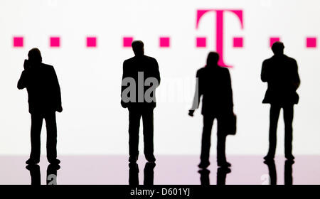 (ABBILDUNG) Eine Abbildung vom 9. November 2012 zeigt kleine Kunststoff-Figuren im Vordergrund des Logos der DAX-Unternehmen: Telekom in Berlin, Deutschland, 9. November 2012. Foto: Sven Hoppe Stockfoto