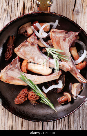 Lamm-Koteletts und Champignons in einer Pfanne erhitzen Stockfoto