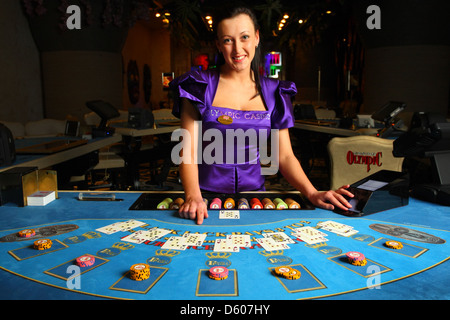 Lächelnde Händler, Croupier zeigt Karten im Casino am Blackjack-Tisch. Europa Stockfoto