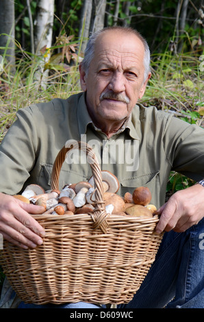 Der Mann mit Korb voller Pilze Stockfoto