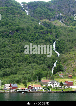 Ein Wasserfall stürzt in ein kleines Bauerndorf auf Naerfjorden, Norwegen Stockfoto