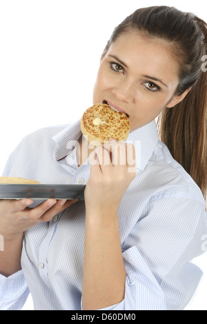 Sicher glückliche junge Frau, alleine essen Traditionelle englische Getoastet mit Butter bestrichenen Gipfeli, isoliert weißer Hintergrund, Freistellungspfad Stockfoto