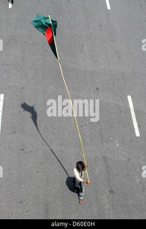 Dhaka, Bangladesch. April 8, 2013. Ein Bangladeshi Straße Kind marschiert mit der nationalflagge als Demonstranten halten Sie eine Anti-strike Rally während eines landesweiten Streik am 8. April 2013, die von Islamisten in Dhaka. Islamistische Organisation, Hefajat-e-Islam einen landesweiten Streik zu drücken, um die nationalen Parlamente eine blasphmey Rechtswissenschaften an der Verfolgung der Blogger beschuldigt, beleidigt den Islam und den Propheten Mohammed in der mehrheitlich muslimischen Landes zu erlassen. Stockfoto