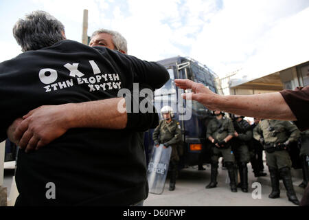 Thessaloniki, Griechenland. 10. April 2013. Ein Demonstrant versucht, ein weiterer Demonstrant vom konfrontieren Aufruhr Polizisten blockieren den Eingang zum Polizeipräsidium zu stoppen. Demonstranten aus Thessaloniki und das Dorf von Ierissos versammelten sich vor dem Polizeipräsidium in Thessaloniki, wo zwei Anwohner von Ierissos nach der Verhaftung über ihre angebliche Miteinbeziehung in einem Februar Brandanschlag auf der Goldmine-Installationen in der Nähe von Ierissos Dorf gehalten werden. Bildnachweis: Konstantinos Tsakalidis / Alamy Live News Stockfoto