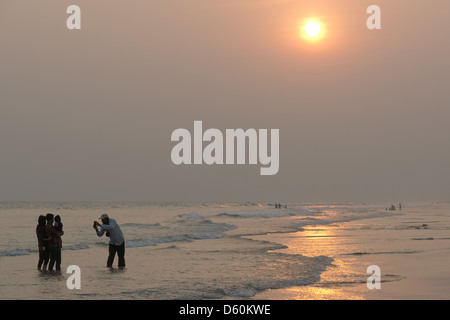Ein Tourist nimmt ein Foto seiner Familie an den Rand des Wassers bei Puri Beach, Odisha, Indien Stockfoto