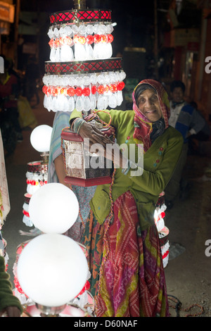 Eine Lampe-Träger hält ihre Lampe empor, während einer Hochzeit Parade in Udaipur, Rajasthan, Indien Stockfoto