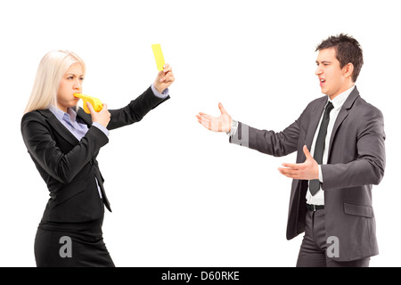 Frau im Business-Anzug zeigt eine gelbe Karte und bläst eine Pfeife mit einem Mann im Anzug, isoliert auf weißem Hintergrund Stockfoto