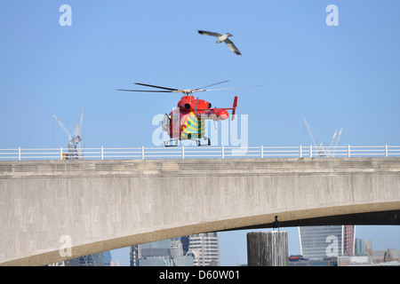 London, England - 2. April 2013: A London Air Ambulance Helikopter landet auf einem Einsatzort auf Waterloo Bridge. Stockfoto