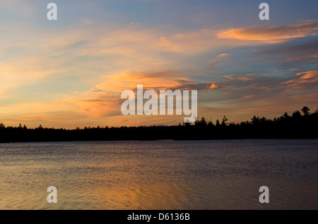 Goldene und orange Wolken bei Sonnenaufgang über Niere Teich, Baxter State Park, Maine Stockfoto