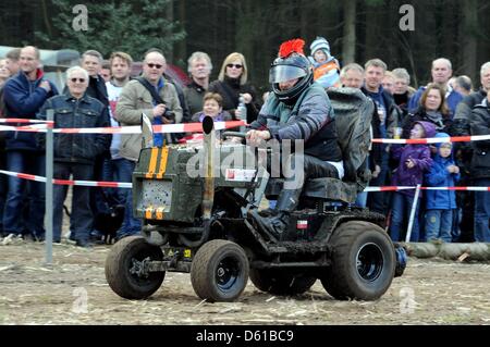 Ein Mann tritt in einem Reiten-auf Rasenmäher-Rennen in Aukrug-Homfeld, Deutschland, 14. April 2012. Rund ein Dutzend Mannschaften mit ihren modifizierten Reiten-auf Rasenmäher mit bis zu 120 PS und oberen Geschwindigkeiten von mehr als 60 km/h in diesem lustigen Rennen. Foto: CARSTEN REHDER Stockfoto