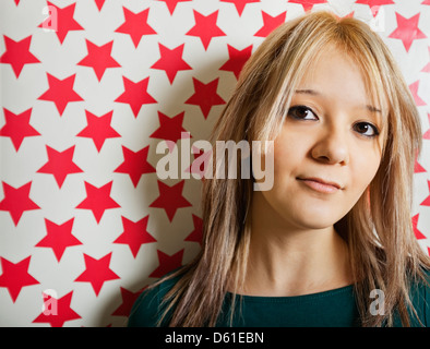 Nahaufnahme der schönen jungen Frau gegen Roter Stern formt Tapete Stockfoto