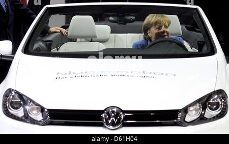 Bundeskanzlerin Angela Merkel ruft hinter dem Lenkrad eines E-Golf bei einem Besuch in das Volkswagenwerk in Wolfsburg, Deutschland, 23. April 2012. Foto: Kay Nietfeld Stockfoto