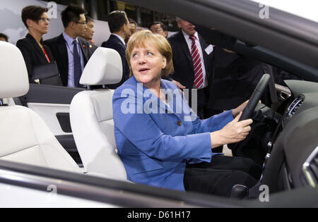 Bundeskanzlerin Angela Merkel ruft hinter dem Lenkrad eines E-Golf bei einem Besuch in das Volkswagenwerk in Wolfsburg, Deutschland, 23. April 2012. Foto: Kay Nietfeld Stockfoto