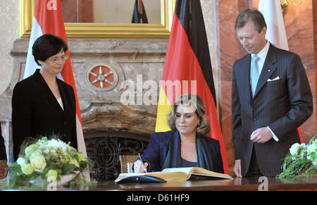 Großherzog Henri von Luxemburg und Großherzogin Maria Teresa Zeichen das Goldene Buch in der Staatskanzlei während Premier von Thüringen Christine Lieberknecht (CDU, L) blickt auf in Erfurt, Deutschland, 25. April 2012. Großherzog Henri ist zum Staatsbesuch nach Deutschland auf Einladung des Bundespräsidenten Gauck. Thüringen ist die letzte Station des Besuchs. Foto: Martin Schutt Stockfoto