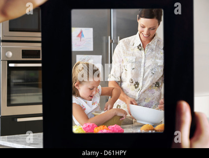 Weibliche Hand Rahmung Mutter Tochter Backen zusammen in Küche Stockfoto