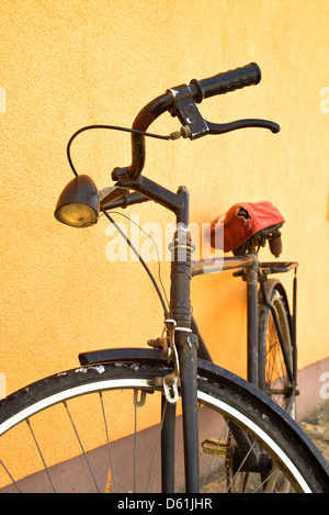 Alte Vintage schwarzes Fahrrad an die Wand gelehnt. Stockfoto