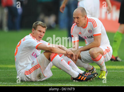 Der Münchner Holger Badstuber (L) und Arjen Robben sitzen auf dem Spielfeld, nachdem die Bundesliga Fußballspiel zwischen FC Bayern München und VfB Stuttgart in der Allianz Arena in München, 28. April 2012. Foto: ANDREAS GEBERT (Achtung: EMBARGO Bedingungen! Die DFL ermöglicht die weitere Nutzung der Bilder im IPTV, mobile Dienste und anderen neuen Technologien nur nicht früher als zwei Hou Stockfoto