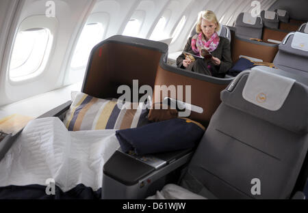 Eine Frau hat ihren Sitz in der Business Class eine neue Boeing 747-8 am Frankfurter Flughafen in Frankfurt Main, Deutschland, 2. Mai 2012 übernommen. Lufthansa ist die erste Fluggesellschaft weltweit ihre Pkw-Flotte der neuen Boeing hinzu. Die neu entwickelten 747-8 ist 5 Meter länger als das Vorgängermodell 747-400 und ist deutlich leiser und effizienter sein soll. Foto: ARNE DEDERT Stockfoto