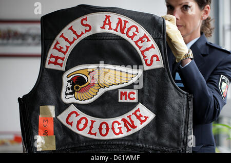 Ein Polizist stellt beschlagnahmten Gegenstände Hauptquartier der Polizei in Köln, Deutschland, 3. Mai 2012. Motorrad-Club "Hells Angels MC Cologne" und Fan-Club "Red Devils MC Cologne" haben verboten und aufgelöst. Foto: Rolf Vennenbernd Stockfoto