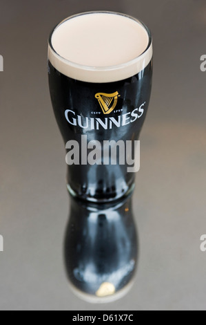 Vertikale Antenne Nahaufnahme von einem vollen Pint Guiness in einer Glasoberfläche reflektiert. Stockfoto