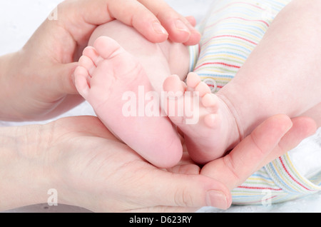 Mutters Hände halten Babys Füße Stockfoto