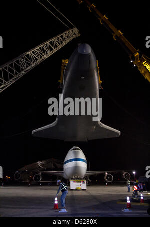 Space Shuttle Enterprise ist empor im Besitz einer gelben Schlinge und eine Reihe von Kranen nachdem es von der Spitze des NASA 747 Shuttle Carrier Aircraft am frühen Sonntagmorgen am John F. Kennedy (JFK) International Airport in New York, Sonntag, 13. Mai 2012 entfernt worden war. Die 747 wurde nach hinten gezogen, damit Unternehmen gesenkt werden konnte. Der Shuttle wird auf einem Lastkahn aufgesetzt werden, die durch Schlepper befördern Stockfoto