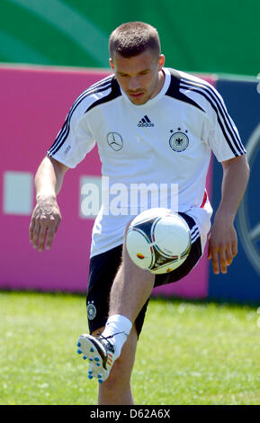 Deutscher nationaler Fußballspieler Lukas Podolski spielt den Ball während einer Trainingseinheit des deutschen nationalen Saoccer Teams bei Andrea Corda Stasium in Abbiadori auf der Insel Sardinien, Italien, 17. Mai 2012. Die deutsche Nationalmannschaft ist derzeit in einem Trainingslager auf Sardinien 2012 UEFA Fußball-Europameisterschaft vorzubereiten. Foto: MARCUS BRANDT Stockfoto