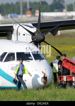 Ein Mann Geht bin Donnerstag (17.05.2012) in München (Oberbayern) Bei Einem Notgelandeten Flugzeug der Italienischen Fluggesellschaft Air Dolomiti, bin Beschädigten Bug Vorbei. Maschine Mit 62 Menschen sterben ein Bord Krieg Kurz Nach Dem Start in Richtung Venedig Umgedreht, Weil Sich Rauch in der Kabine Entwickelt wegdrücken. Bei der Landung Wurden Fünf Personen Leicht Verletzt, sterben Maschine ka Stockfoto