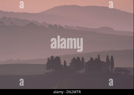 Einen Sonnenaufgang Blick auf "Penella" ein toskanisches Bauernhaus, umgeben von sanften Hügeln und Zypressen in der Toskana Val D'Oricia Stockfoto