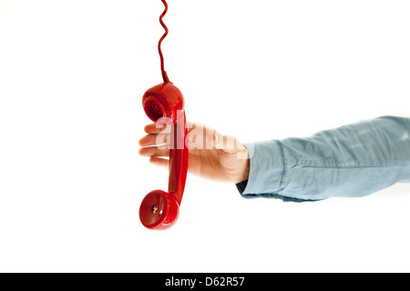 Männliche Hand packte eine rote Telefon. isoliert auf weiss. Stockfoto