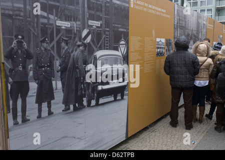 Besucher lernen über die Berliner Mauer zu lesen im freien Schautafeln in der Nähe der ehemaligen Checkpoint Charlie, die ehemalige Grenze zwischen Ost und West Berlin während des Kalten Krieges. Die Berliner Mauer war eine Barriere, die von der Deutschen Demokratischen Republik (DDR, Ostdeutschland) ab dem 13. August 1961, gebaut, die völlig abgeschnitten (Landweg) West-Berliner aus den umliegenden Ostdeutschland und aus Ostberlin... (Mehr in Beschreibung). Stockfoto