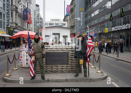 Junge Männer nachzustellen, den ehemaligen Grenzübergang zwischen Ost und West Deutschland während des Kalten Krieges auf dem Gelände des ehemaligen Checkpoint Charlie, der Grenze. Die Berliner Mauer war eine Barriere, die von der Deutschen Demokratischen Republik (DDR, Ostdeutschland) ab dem 13. August 1961, gebaut, die völlig abgeschnitten (Landweg) West-Berliner aus den umliegenden Ostdeutschland und aus Ostberlin. (Mehr in Beschreibung)... Stockfoto