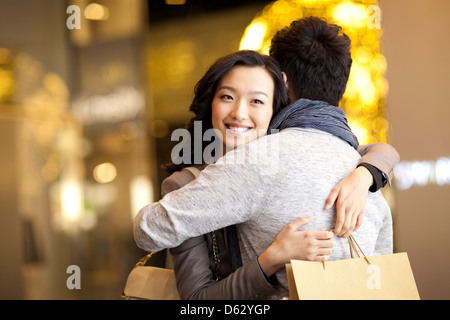 Süße junge Paar umarmt mit Einkaufstasche in Händen Stockfoto