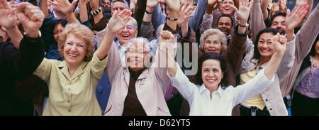 Große Gruppe von multi-ethnischen Menschen jubeln mit rms angehoben Stockfoto