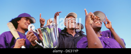 Panorama-Aufnahme der fröhlichen Baseballspieler mit Trophäe feiern Sieg gegen klarer Himmel Stockfoto