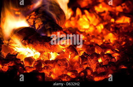 Niederbrennen von Feuerholz in den Ofen Stockfoto