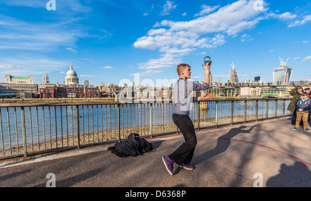 Straßenkünstler jongliert mit einer Kristallkugel an der Themse-Promenade, South Bank, London, England, Großbritannien. Stockfoto