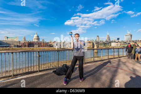 Straßenkünstler jongliert mit einer Kristallkugel an der Themse-Promenade, South Bank, London, England, Großbritannien. Stockfoto