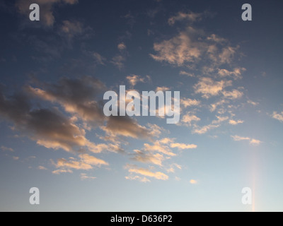 Dieses Bild zeigt dunkle Wolken, die über den Himmel verstreut sind und während eines Sonnenuntergangs einen Lichtstrahl durchbrechen. Der Kontrast von Licht und Schatten erzeugt einen dramatischen Effekt. Verfügbar zur kostenlosen Nutzung unter der öffentlichen Domain. Stockfoto