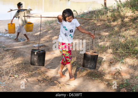 Junges Mädchen mit einem Koffer voller Wasser, Minnanthu, Bagan, Myanmar (Burma) Stockfoto