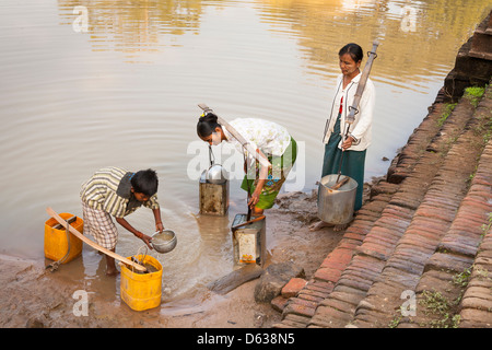 Dorfbewohner Wasserbehälter einfüllen von Wasser, Minnanthu, Bagan, Myanmar (Burma) Stockfoto