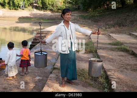 Frau mit einem Koffer voller Wasser, Minnanthu, Bagan, Myanmar (Burma) Stockfoto