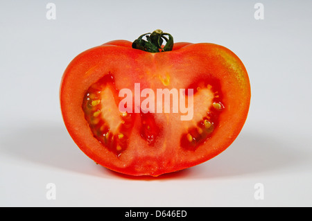 Halb ein Beefsteak Tomaten vor einem weißen Hintergrund. Stockfoto