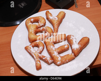 Dieses Bild zeigt Donuts in Form von Buchstaben, eine kreative Note des klassischen Donut-Designs. Die Donuts sind in verschiedenen Farben dekoriert und sehen optisch ansprechend aus. Stockfoto