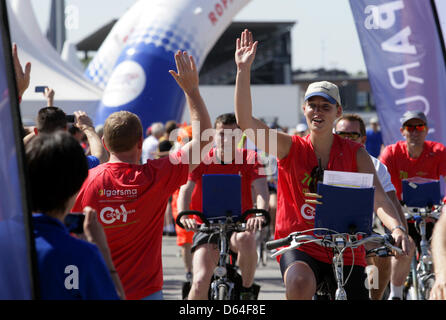 Ein Radfahrer gibt hohe Fives, das Publikum zu Beginn des "Roparun" in Hamburg, Germany, 26. Mai 2012. Teilnehmer des run sammeln Geld für Krebspatienten mit dem Staffellauf zwischen Hamburg und Rotterdam. Foto: DANIEL BOCKWOLDT Stockfoto