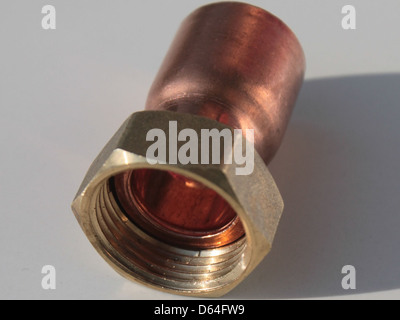 Ein gerader Hahnanschluss aus Kupfer mit Endzufuhr, der in Rohrleitungssystemen für die Wasserverteilung verwendet wird. Er ist für die Verbindung von zwei Rohren ausgelegt und sorgt für eine sichere, leckfreie Verbindung. Stockfoto