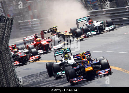 Australischen Formel1-Fahrer Mark Webber von Red Bull führt die Packung nach Beginn des Grand Prix von Monaco beim Formel 1-Rennen verfolgen von Monte Carlo, 27. Mai 2012. In der Backround deutsche Formel-1-Pilot stürzt Michael Schumacher (R) of Mercedes AMG mit französischer Formel-1 Fahrer Romain Grosjean (2-R) von Lotus. Foto: Jens Buettner +++(c) Dpa - Bildfunk +++ Stockfoto