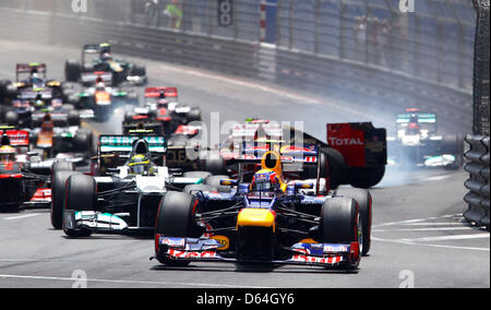 Australischen Formel1-Fahrer Mark Webber (C) von Red Bull führt die Packung nach Beginn des Grand Prix von Monaco beim Formel 1-Rennen verfolgen von Monte Carlo, 27. Mai 2012. In der Backround deutsche Formel-1-Pilot stürzt Michael Schumacher (R) of Mercedes AMG mit französischer Formel-1 Fahrer Romain Grosjean (C zurück) von Lotus. Foto: Jens Buettner +++(c) Dpa - Bildfunk +++ Stockfoto